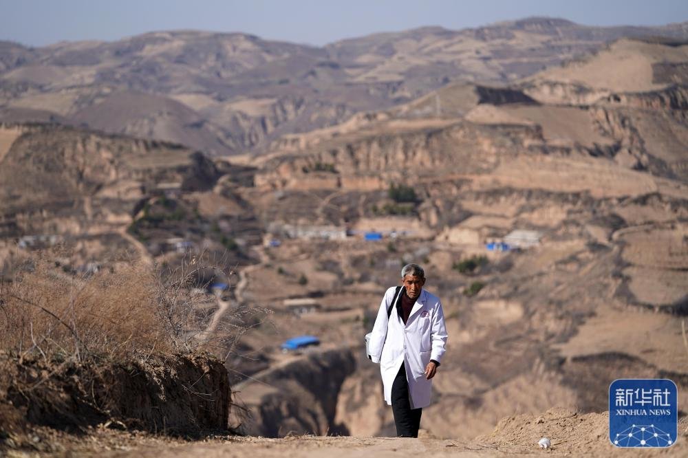 山西吕梁石楼县铁头村的乡村医生张尚保走在出诊路上(2021年3月23日摄)。新华社记者 詹彦 摄